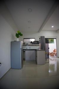 a white kitchen with a refrigerator and a table at Duplex NR in Nu Guazu