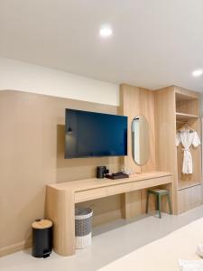 a room with a desk with a tv and a mirror at Abundant Eco Hostel in Laguna Phuket