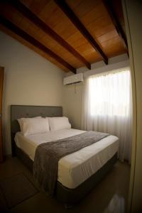 a large bed in a bedroom with a window at Duplex NR in Nu Guazu
