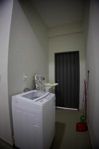 a washing machine in a room with a black door at Duplex NR in Nu Guazu