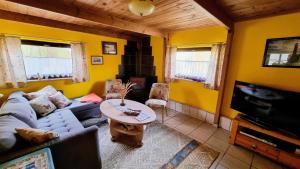 a living room with a couch and a table at Ferienhaus Julchen Samtens - mit Garten, Grillplatz, Sauna in Samtens