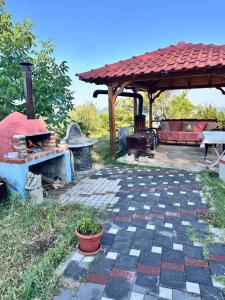 a patio with a fireplace and a gazebo at Bodini Mountain House in Peqin