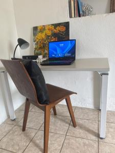 a desk with a laptop computer on top of it at Cerca de Aeropuerto , bleseed house in Monte Adentro