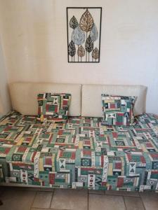 a bed with a quilt and two pillows on it at Vromolithos apartments in Nisís Léros