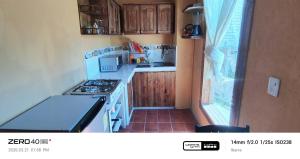 a small kitchen with a stove top oven next to a window at "De HugoS" hospedaje in Ibarra