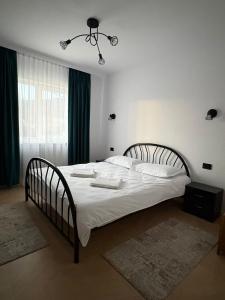a bedroom with a large bed with white sheets at Borșa ApartHotel 5 in Borşa