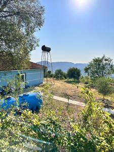 a water tower sitting on the side of a house at Bodini Mountain House in Peqin +6 photos