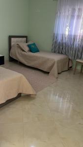 two beds sitting next to each other in a room at Bodini Mountain House in Peqin