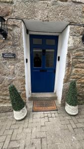 a blue door with two hedges in front of it at Minster Panorama & Minster Vista - - UNBROKEN BEACHFRONT VIEWS - - TWO STUNNING GEORGIAN HOUSES THAT CONNECT - - PRIVATE PARKING - - Beautifully Refurbished MARCH 2026 in St Ives