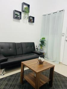 a living room with a black couch and a coffee table at Casa Verde in San Miguel