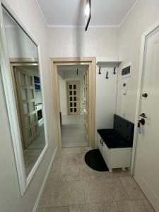 a hallway with a mirror and a black bench at Fancy Bonjour - modern apartment in Iaşi