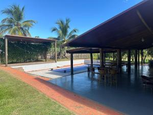 a pavilion with tables and chairs and palm trees at Hotel e Pousada Martini in Sorriso +18 photos