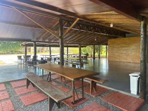a group of tables and benches under a pavilion at Hotel e Pousada Martini in Sorriso