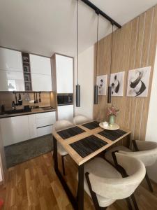 a dining room with a wooden table and chairs at Lenka Lux Apartmans in Divčibare