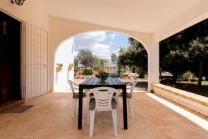 a table and chairs on a patio with an archway at Villa Oasis in Torre Lapillo