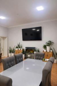 a living room with a table and a tv on a wall at Hostel DANEXAN APA in Nukus