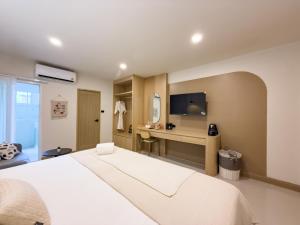 a hotel room with a bed and a desk at Abundant Eco Hostel in Laguna Phuket