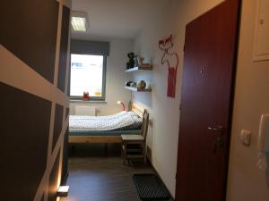 a hallway with a room with a bed and a window at Apartament Nad Galerią in Stargard