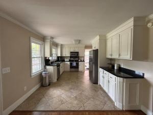 a kitchen with white cabinets and black counter tops at Lux Minimum 2 Lexington With Riverwalk & CAE in West Columbia