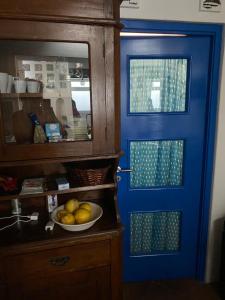 a blue door in a kitchen with a bowl of fruit at Casa Civetta in Stromboli