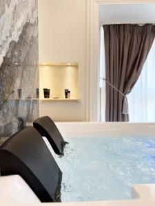 a bath tub filled with water in a bathroom at Domus De Cinti in Tivoli
