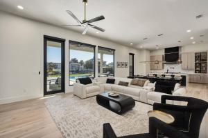 a living room with white furniture and a kitchen at Isle Be Back in Destin