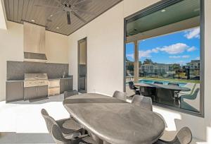 a kitchen with a table and a large window at Isle Be Back in Destin