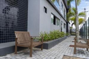 two wooden benches sitting outside of a building at Bananeiras Solar in Bananeiras