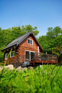 a log cabin with a porch and a deck at Montagne le Maelström in Lac-Beauport
