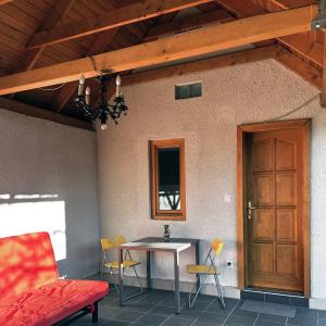 a patio with a table and chairs and a wooden door at Kisház in Kisoroszi