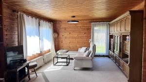 a living room with a couch and a tv at Ferienhaus Waldliebe in Grafenau