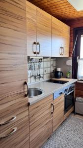 a kitchen with wooden cabinets and a sink at Ferienhaus Waldliebe in Grafenau