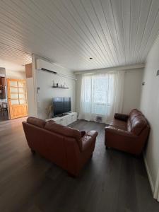 a living room with two leather couches and a television at Apartment Koivikkotie in Savonlinna