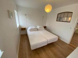 a white room with a bed and a light at 20334-Samso-Kaerbakken-13 in Hårdmark