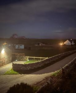 a night view of a field with a stone wall at The Black Sheep Shepherd's Hut in Prestrie