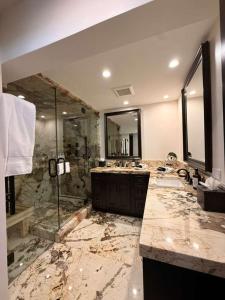 a bathroom with two sinks and a glass shower at Spacious 3 & 3 in Aspen's Core with Sauna in Aspen