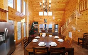 a dining room with a large wooden table and chairs at Lovely Platog Chalet with jacuzzi in Morzine