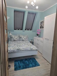 a bedroom with a bed and a blue wall at Eleganckie Lokum in Malbork
