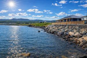 a house on the shore of a body of water at Augustus Jane Inn in Rocky Harbour