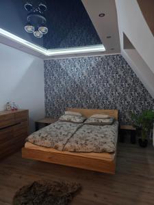 a bedroom with a bed and a blue wall at Eleganckie Lokum in Malbork
