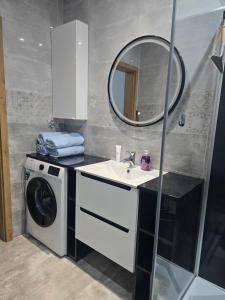 a bathroom with a washing machine and a sink at Eleganckie Lokum in Malbork +8 photos