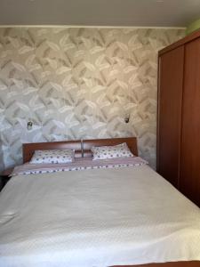 a bed with two pillows and a wall with at Apartment Dream in Boreti