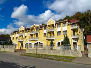 a yellow building with a fence in front of it at Сонячна Квітка in Polyana