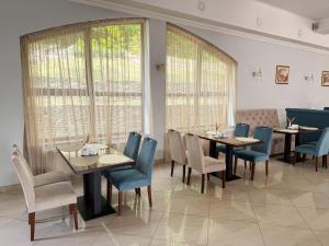 a dining room with tables and chairs and windows at Сонячна Квітка in Polyana