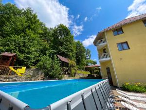 a house with a swimming pool next to a building at Сонячна Квітка in Polyana