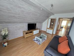 a living room with a couch and a tv at Ferienwohnung U28 in Ferlach