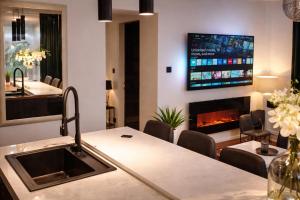 a kitchen with a fireplace and a tv on the wall at Villa Verde Royal in Kaštela