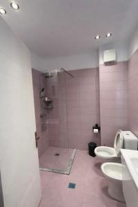 a pink bathroom with two toilets and a shower at FIN Skyline Apartment in Krujë +13 photos