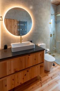 a bathroom with a sink and a toilet and a mirror at Casa Aromas in Santo Amaro