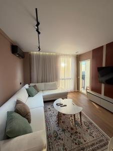 a living room with a white couch and a table at FIN Skyline Apartment in Krujë
